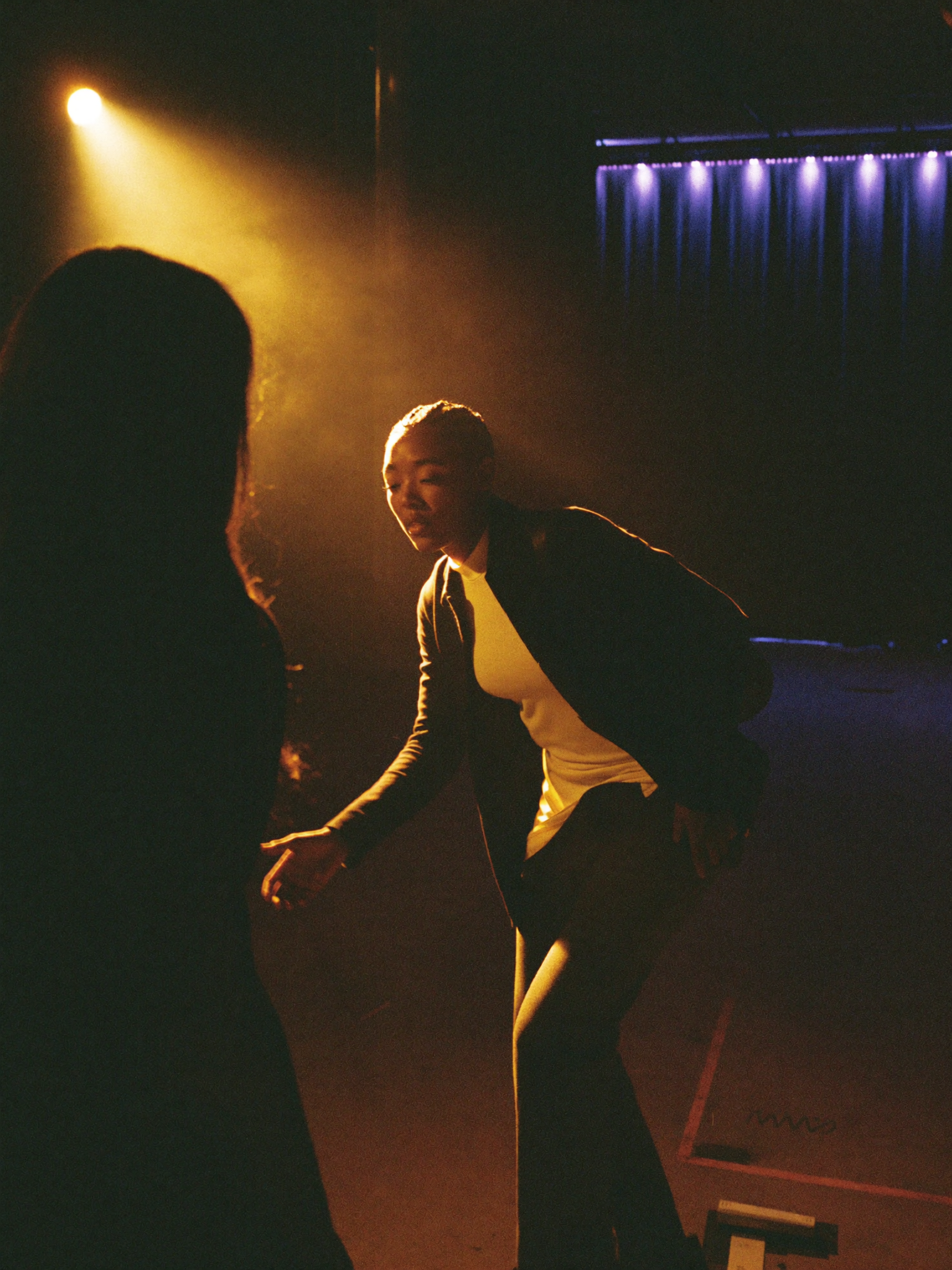 Actress mid-scene with partner silhouette